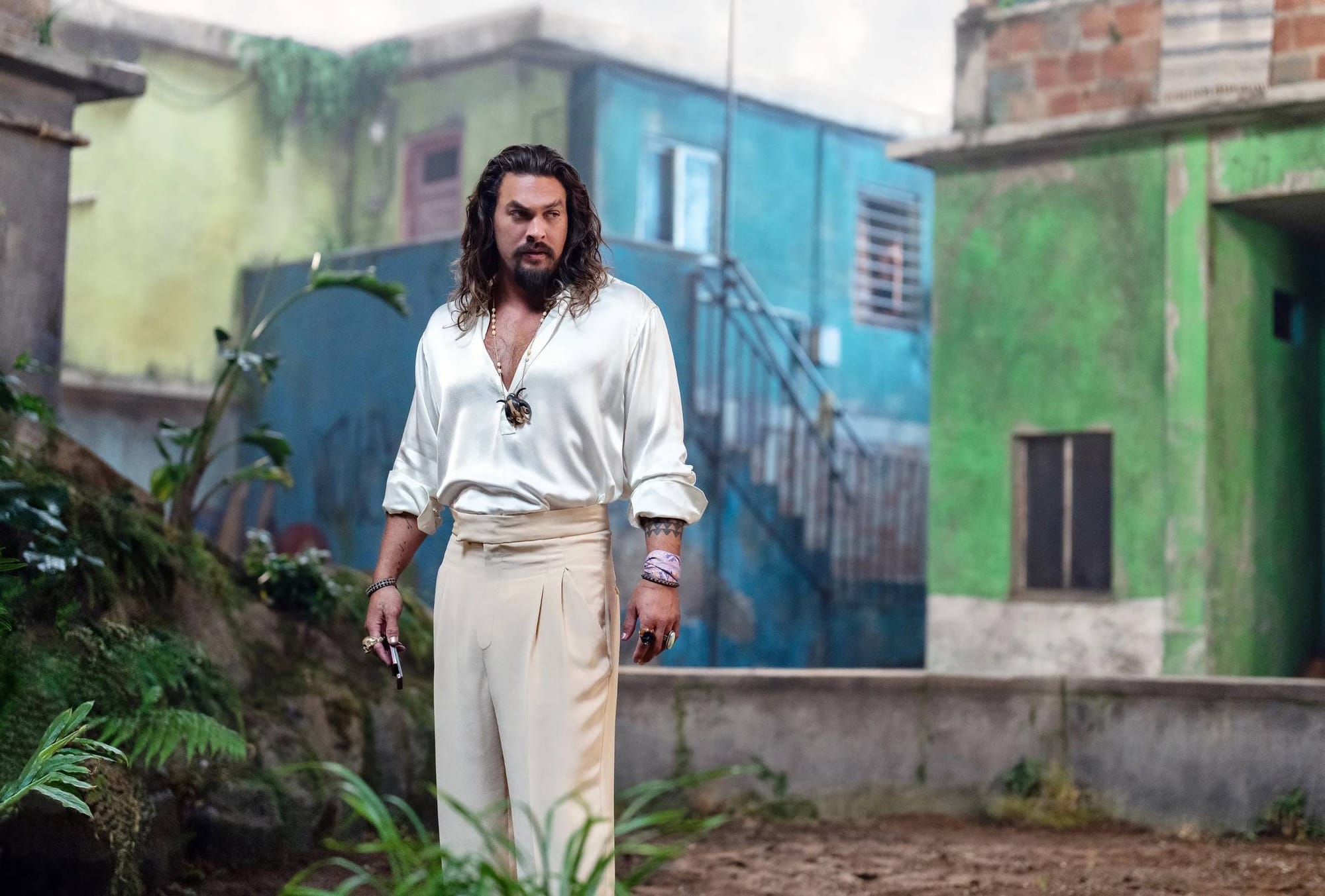 A still from Fast and Furious X - Jason Momoa in front of green and blue buildings