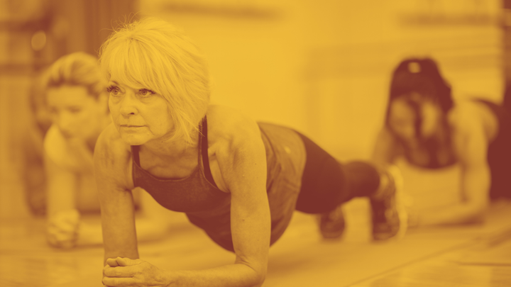 A photo of an older woman in a plank position looking like she could hold it all day. 