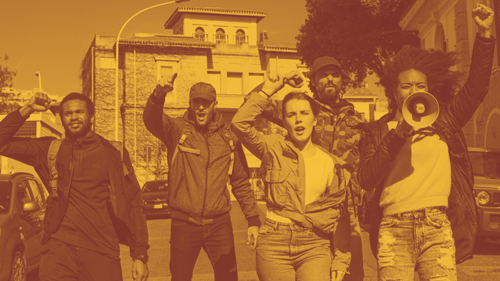 A photo of five young people with power fists raised, one yelling through a bullhorn.