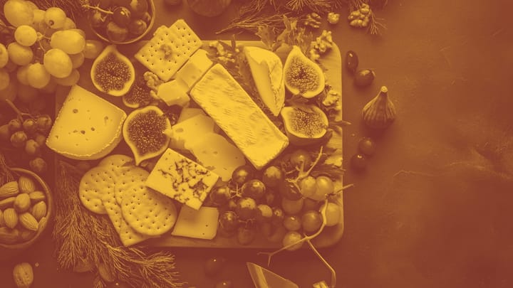 A photo or a cheese board with some greenery on the side.